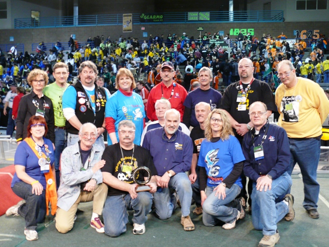 Dr. Woodie Flowers posing with a group of WFA recipients on the field during a competition